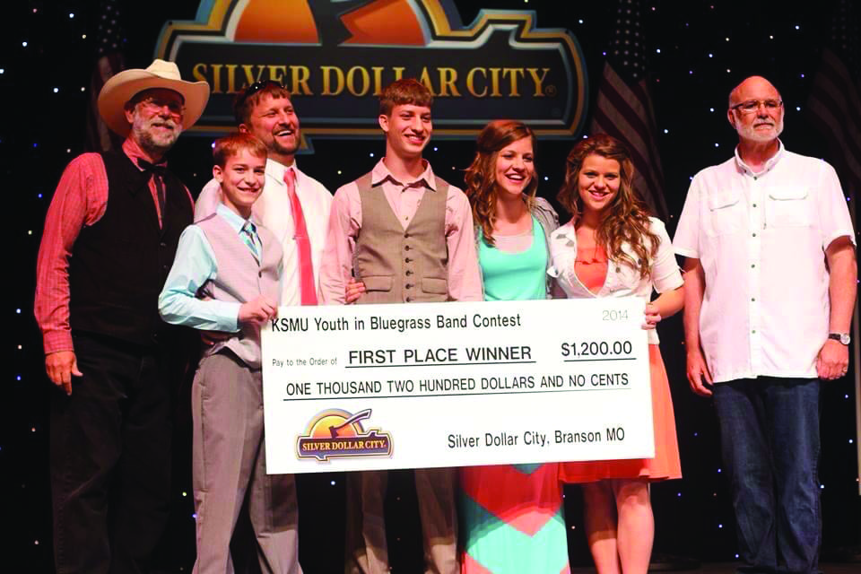 Silver Dollar City Entertainment Manager, D. A. Callaway and Mike Smith with the 2014 KSMU Youth in Bluegrass Band Contest winners, the Lindsey Family of Greensburg, Kentucky. Photo courtesy Silver Dollar City.