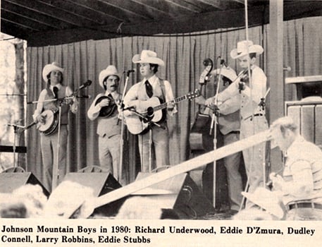 The Johnson Mountain Boys performing together on stage while wearing suits and cowboy hats