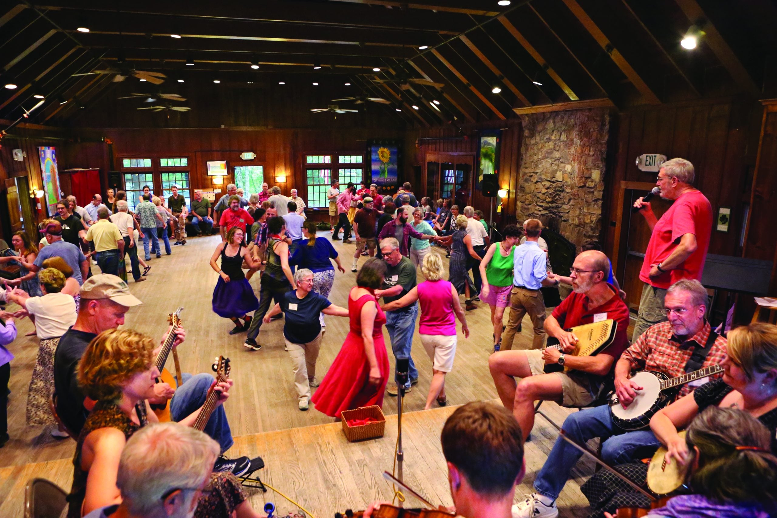 Top: A banjo display hangs in the History Center on the campus of the John C. Campbell Folk School.  //  Photo by Vicki Dean Bottom: The Folk School is known for contra dancing. Here pre-pandemic dancers perform in the Keith House Community room.