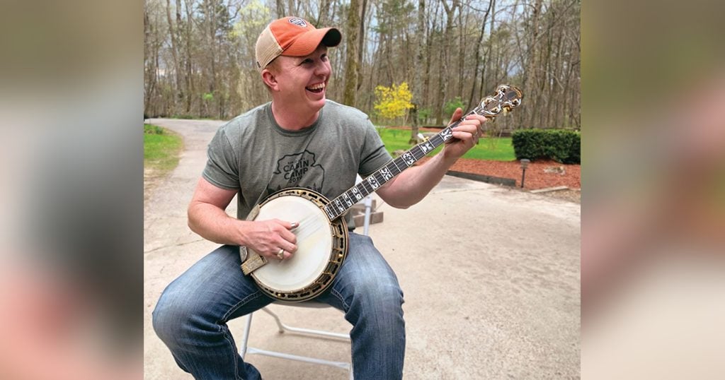 Ben Clark smiling and playing his banjo