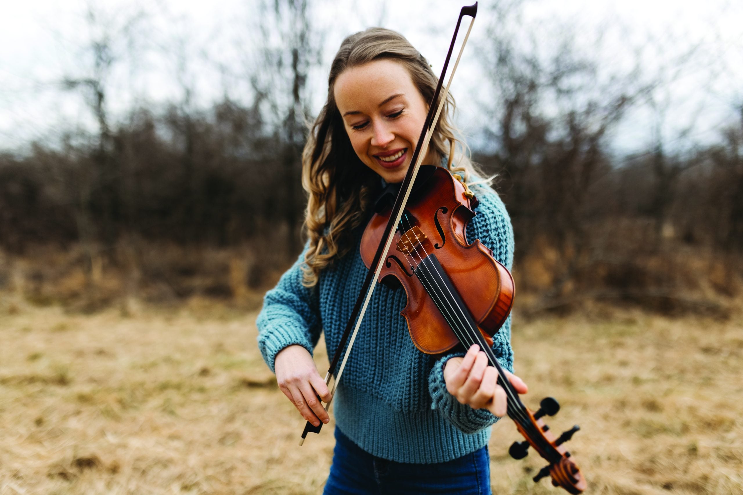 Bronwyn smiling and playing her fiddle.