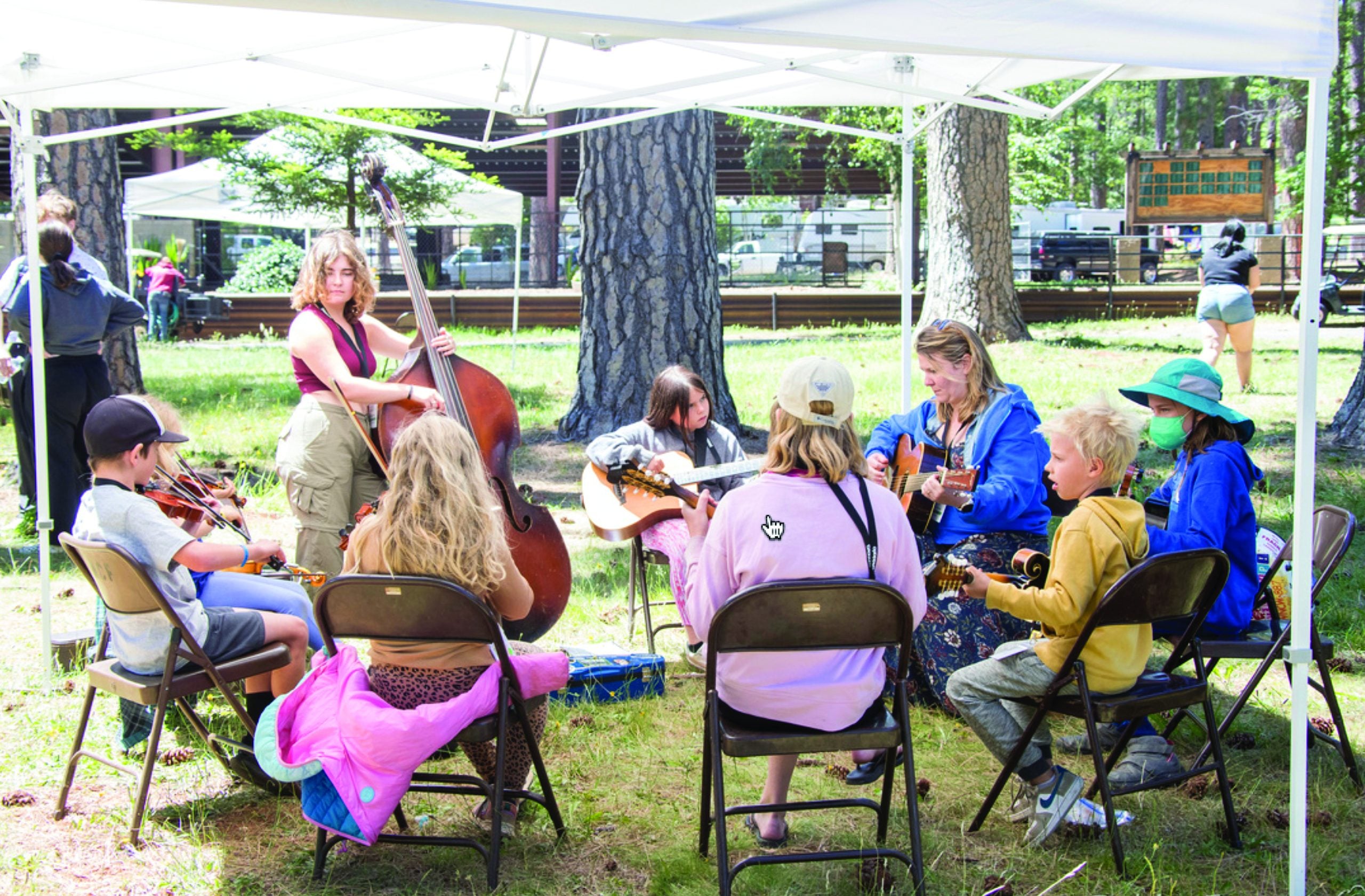 Della Mae’s Celia Woodsmith working with kids at the 2022 CBA Youth Academy.  Photo property of California Bluegrass Association.