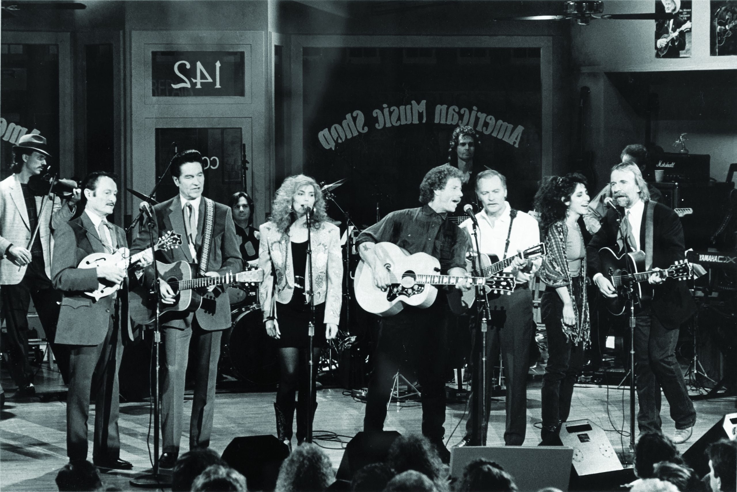 Chris Hillman hosts the America Music Shop with (left to right) Mark O’Connor, Jesse McReynolds, Jim McReynolds, Harry Stinson (drums), Emmylou Harris, Chris Hillman, Vern Gosdin, Tish Hinojosa, and Herb Pedersen. Photo courtesy of Hillman Archives.