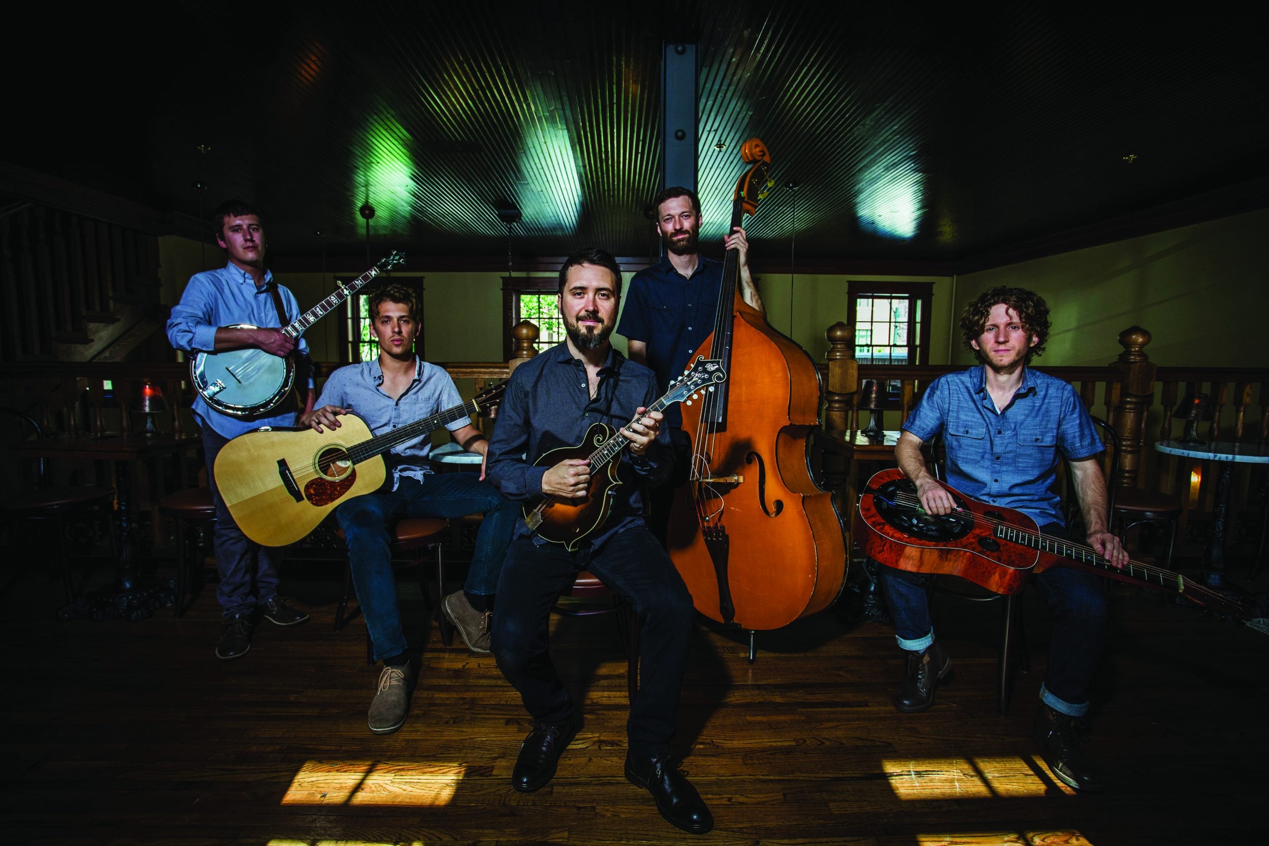 Group portrait of the band smiling with their instruments in hand.