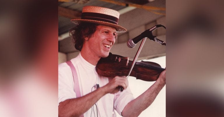 Image of John Hartford playing his instrument on stage