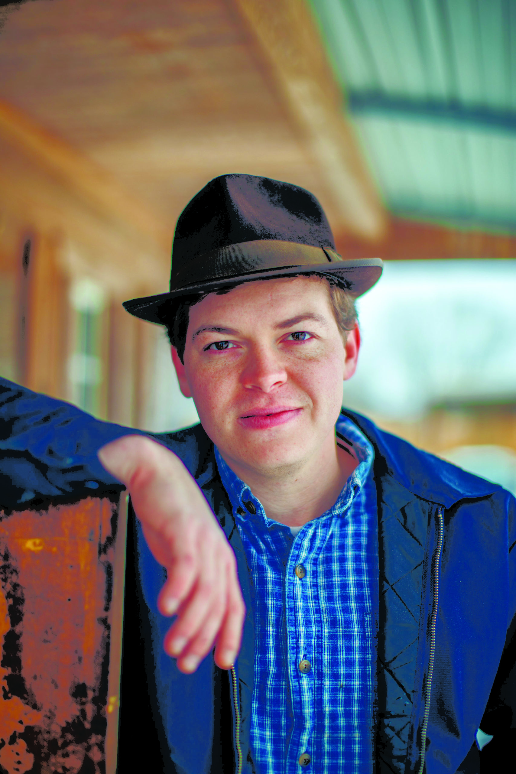 Gaven poses for a photo with his arm perched on a wooden beam