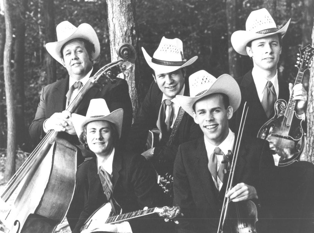 The Johnson Mountain Boys smile for a group photo while holding their instruments.