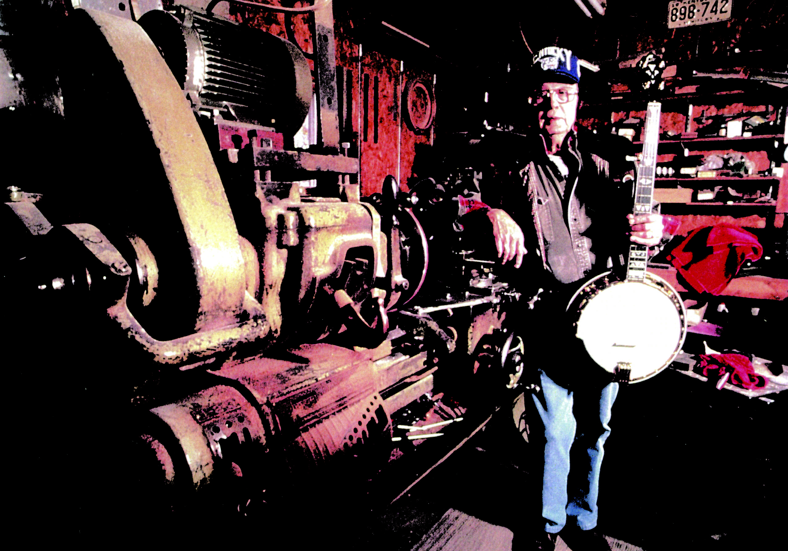 Jimmy Cox posing with a banjo in his shop