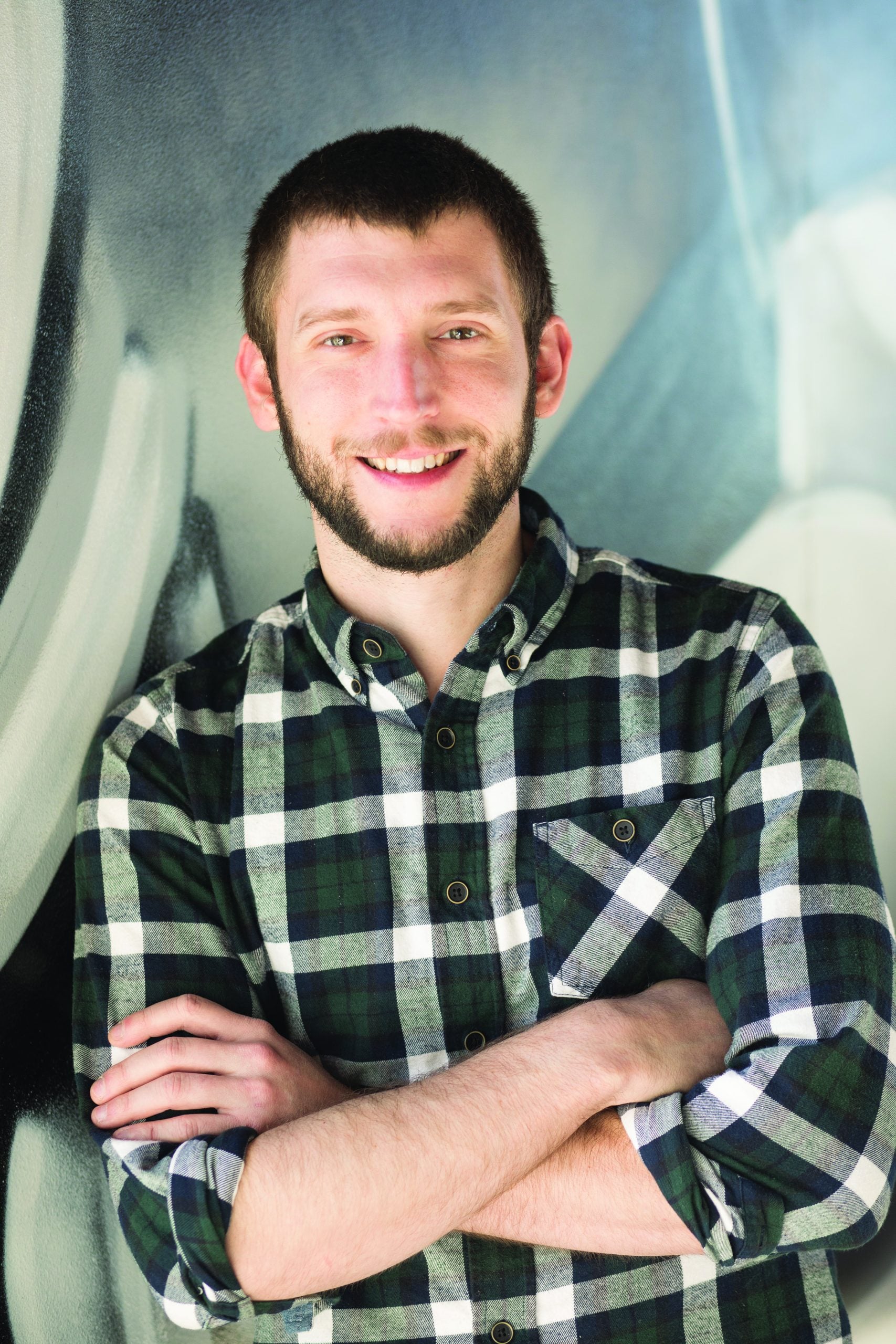 Ben Mason poses for a picture with his arms crossed across his chest smiling