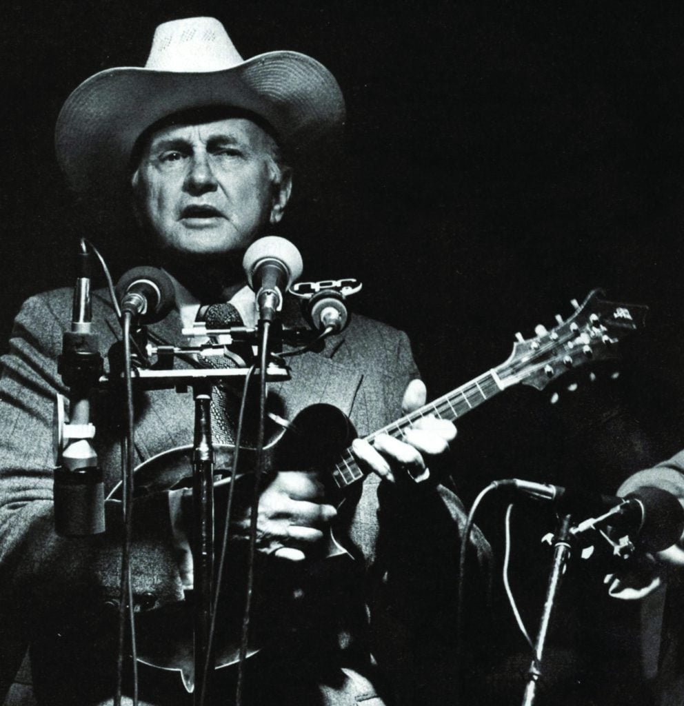 Bill Monroe speaking to a crowd of people.