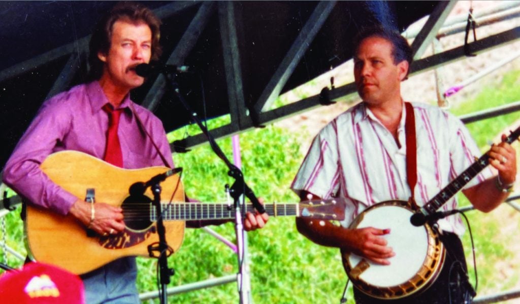 Tony Rice and Pete Wernick performing on stage together.