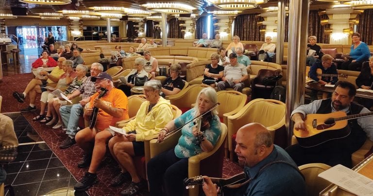 Danny Stewart (bottom right with singer/guitarist Greg Blake sitting behind him) at a jam session on the Alaska bluegrass cruise in 2017.