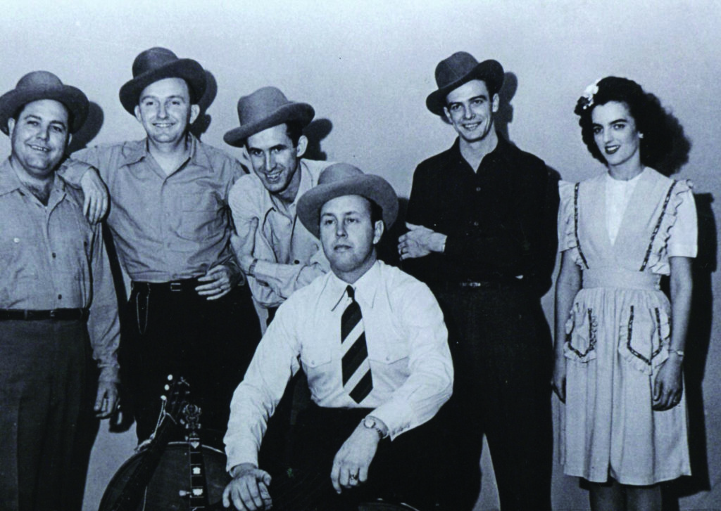 Stringbean with Bill Monroe (seated) and (left to right) Andy Boyette, Lester Flatt, Stringbean, Monroe, Jim Shumate, and Billie “Sally Ann” Forrester. Photo courtesy of the Bluegrass Music Hall of Fame & Museum, Bluegrass Unlimited collection.