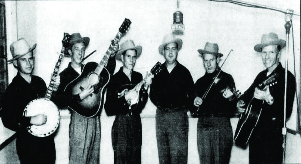 Early 1950s grouping of the Virginia-based Rocky Mountain Boys. From left to right: Jimmy Price (banjo), Bobby Smith (guitar), Hubert Lovern (mandolin), Lewis Kanode (announcer), Avery “Red” Linkous (fiddle), and Clifford Lovern (guitar).