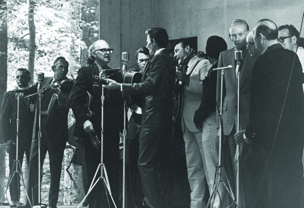 Sunday Morning Gospel singing at Bean Blossom 1971. (L-R) Unidentified, Kenny Baker, Joe Stuart (hidden), Bill Monroe, Jack Hicks, Travis Stewart, Don Reno, unidentified, Red Smiley, Birch Monroe, Carl Story, Bill Harrell.  Photo by Ron Petronko.  Courtesy of the Bluegrass Music Hall of Fame & Museum.