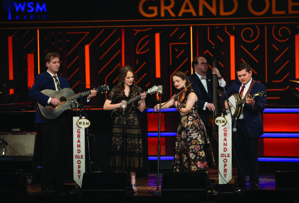 The Price Sisters performing at the Grand Ole Opry.  (left to right) Conner Vliestra, Lauren Price, Leanna Price, Bobby Osborne II and Trevor Holder.  //  Photo by Sophia Sharp