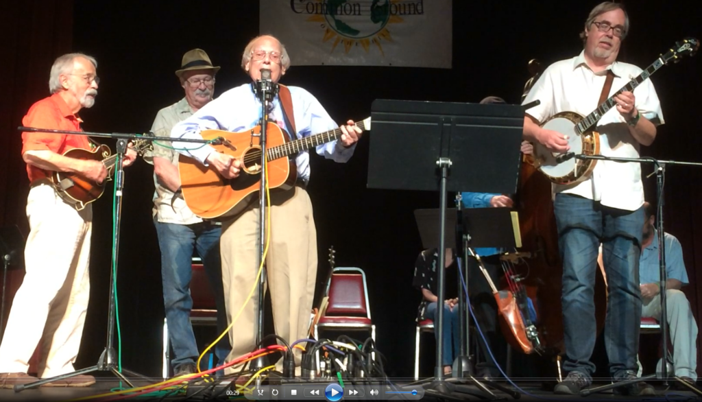 Steve Mandell playing guitar and singing “I Am My Own Grandpa” with  staff of CGOH Traditions Week in 2014 (L to R- Roland White, Steve Mandell, Dudley Connel, Tony Trischka).  Photo courtesy of Common Ground on the Hill