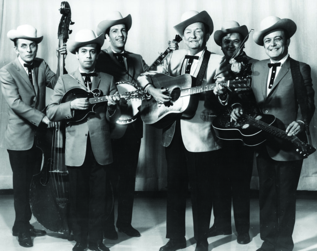 Lester Flatt and the Nashville Grass (left to right) Jake Tullock, Roland White, Vic Jordan, Lester Flatt, Paul Warren and Josh Graves. Bluegrass Unlimited Magazine Archives