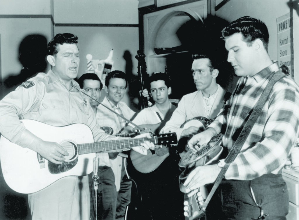 The Country Boys (later the Kentucky Colonels) on the Andy Griffith Show. (left to right) Andy Griffith, Roland White, Eric White Jr., Clarence White, Billy Ray Lathan and LeRoy McNees. Bluegrass Unlimited Magazine Archives