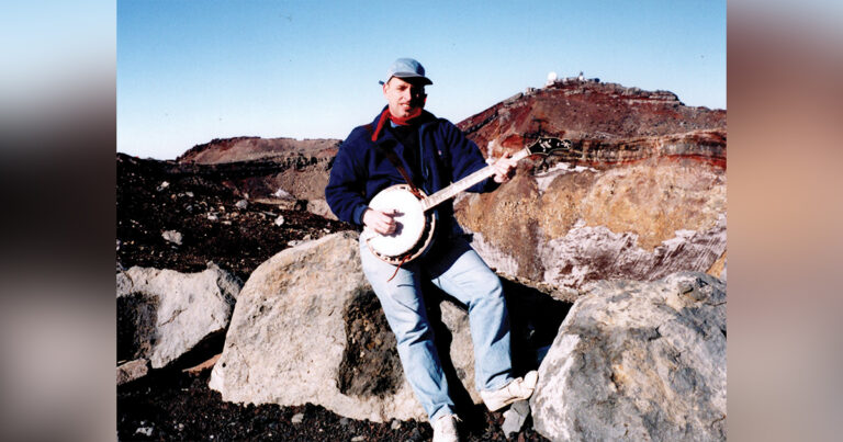 Mark Maggiolo playing banjo atop Mount Fujiyama, Japan in 1996.