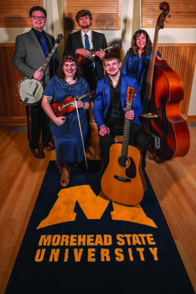Morehead State University Program Director Daxson Lewis (holding the banjo) with students. // Photo by Hallie Adams