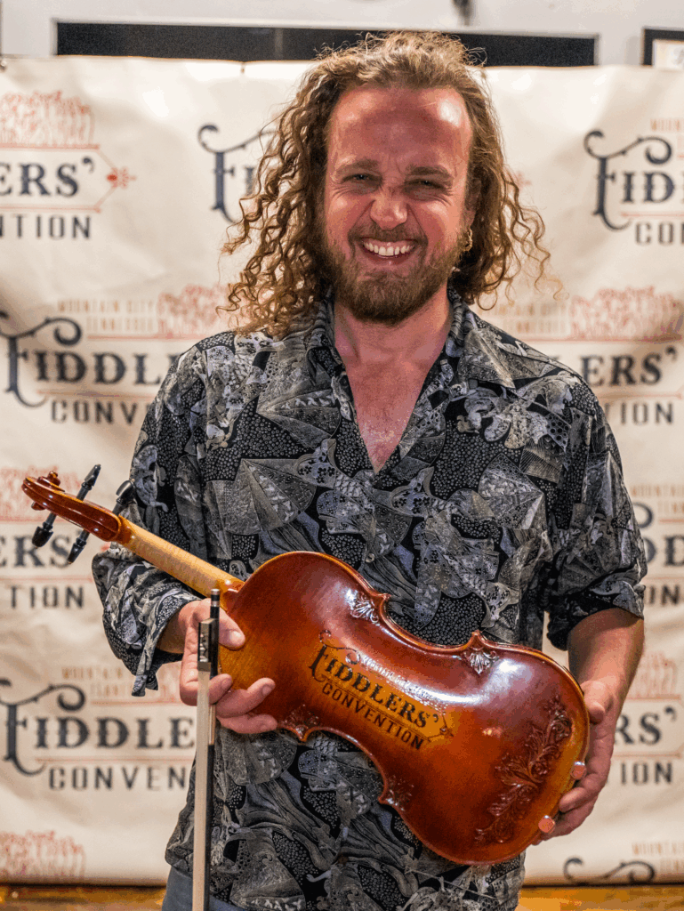 Mountain City Fiddlers’ Convention 2024 Grand Champion Timon Veelenturf from Rotterdam, Netherlands, with his prize fiddle.  //  Photo by Sheila Caldwell