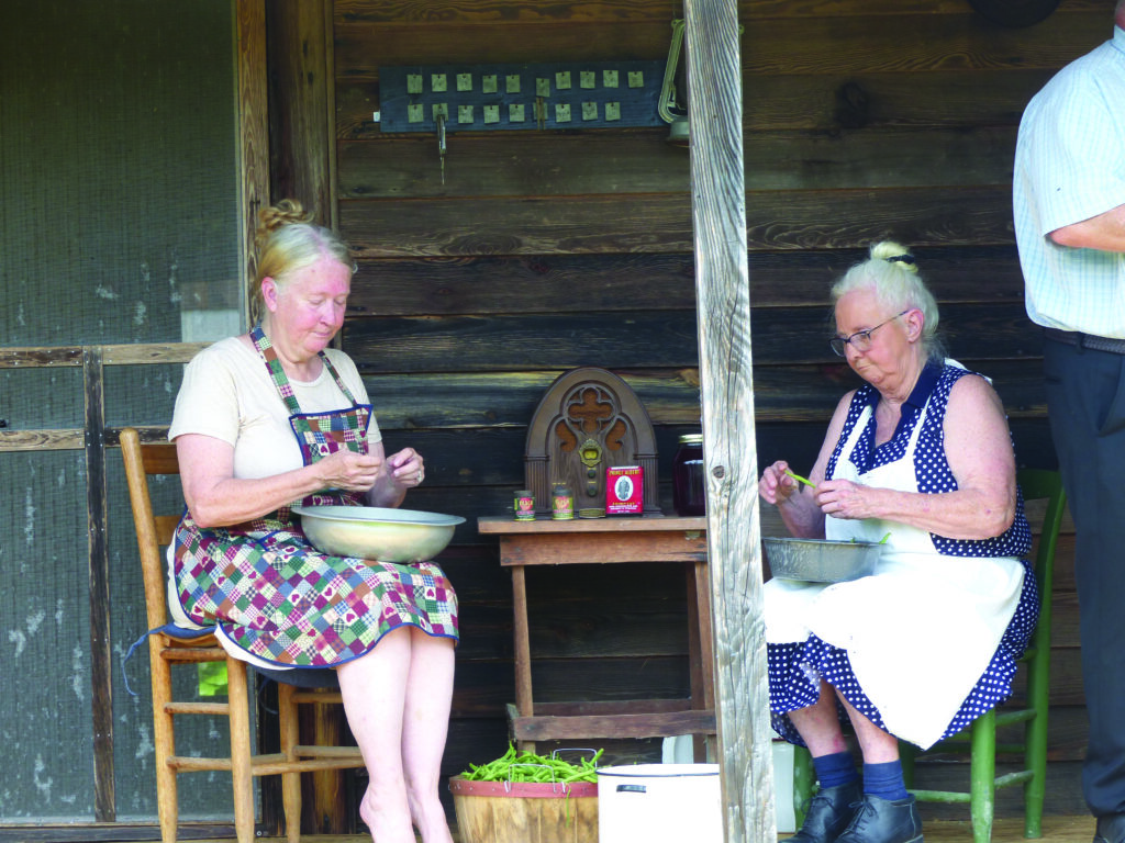 Cousins, Debbie Pennington and Vivian Pennington Hopkins, stringing beans during the making of the music video on the porch of the Cabin in Caroline (Vivian’s mom’s home place).  //  Photo by Sandy Hatley 

