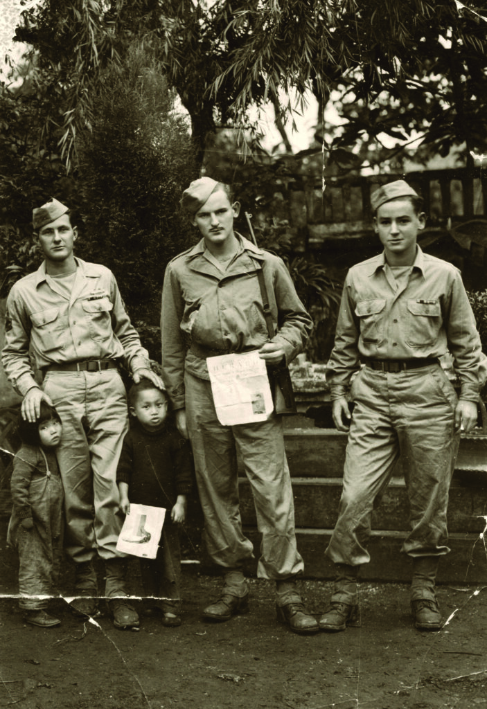 Don Reno (center) holding “Good News Herald” paper, WWII, 1944.  Photo Courtesy Reno Family/Jeremy Stephens Collection