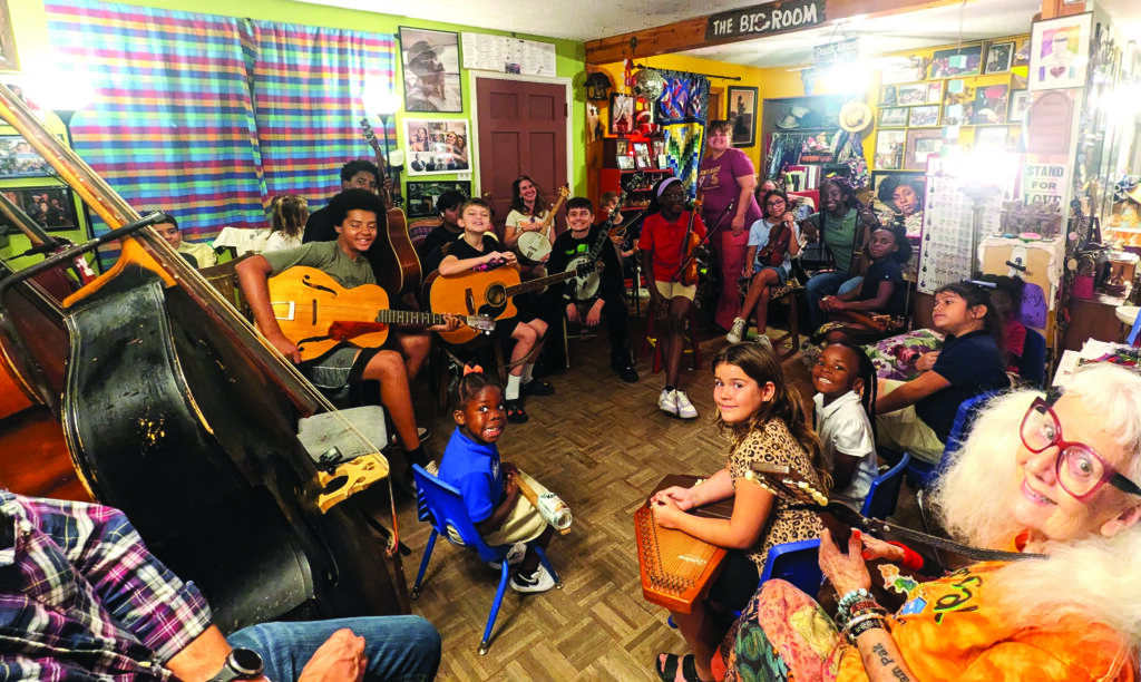 Several Jam Pak band members gathered in Anni Beach’s living room in Chandler, AZ, to welcome and play some music with visitors from Junior Appalachian Musicians in Virginia last October.  //  Photo by Blanche Fletcher, J.A.M.